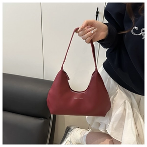 Close-up of deep red leather shoulder bag with gold Fashion & Bags lettering detail