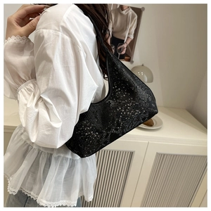 Detailed texture of black snakeskin patterned half-moon underarm bag with zipper