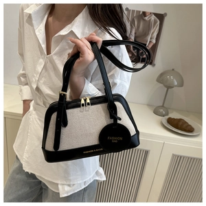 Detail of canvas tote bag showing the contrast stitching and fashion bag pendant