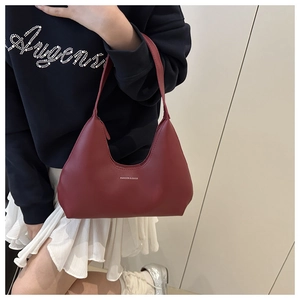 Detail view of burgundy minimalist shoulder bag with white fashion text on model