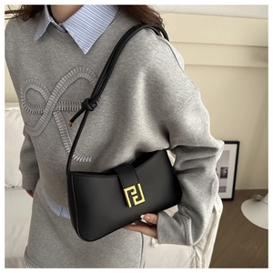 Close-up of black leather handbag featuring a gold interlocking FF metal buckle on a model