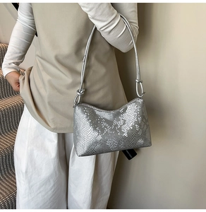 Detail of silver snake pattern shoulder bag with decorative knot on the thin strap