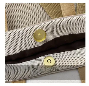 Close-up of golden magnetic snap button on large capacity woven tote bag interior