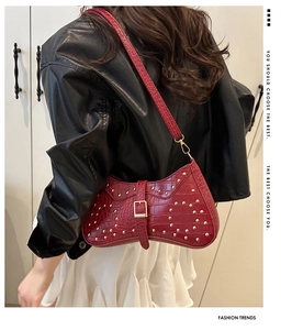 Détail du sac croissant marron rouge à motif croco avec rivets dorés et boucle chic