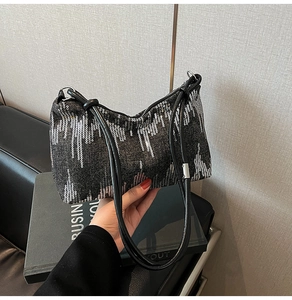 Close-up of black sequined underarm bag showing detailed vertical glitter texture and straps