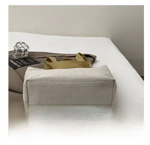 Detail view of the reinforced wear-resistant base on this beige canvas tote bag