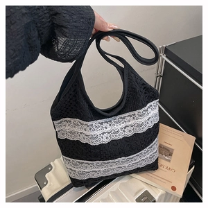Détail du sac cabas en dentelle noire avec bordure en dentelle blanche et large anse