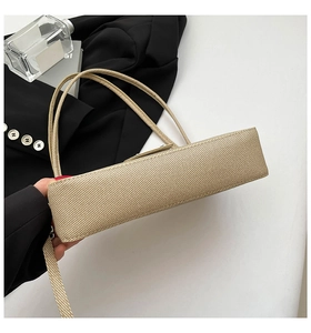 Macro detail of beige woven texture and slim handles on an elegant minimalist handbag