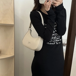 Detailed shot of cream matte leather half-moon bag featuring a gold bow logo and zipper