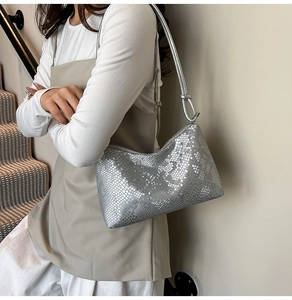 Detail of silver snake-embossed leather underarm bag with unique shoulder strap knot