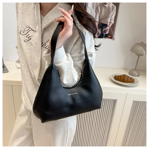 Classic black hobo shoulder bag with silver lettering shown in a stylish lifestyle setting