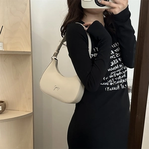 Detail of cream half-moon hobo bag with silver bow hardware and adjustable strap