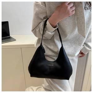 Close-up of a black leather underarm bag with a white Fashion & Bags logo print