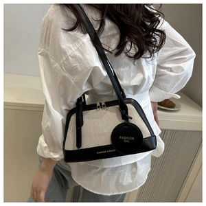 Detailed view of the canvas tote bag showing black leather trim and Fashion & Bags text