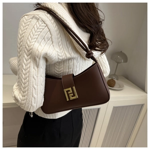 Detail view of brown faux leather bag with golden double F buckle and knot strap detail