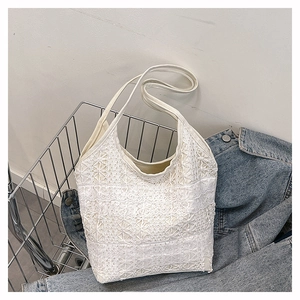 Détails des motifs complexes de dentelle florale blanche sur ce sac fourre-tout