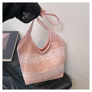 Détail d'un sac cabas en dentelle rose avec des finitions élégantes en dentelle blanche