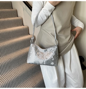 Chic silver underarm bag with snake texture pattern and elegant shoulder strap knot detail