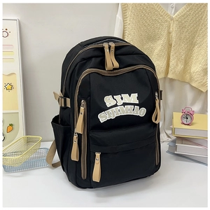 Close-up of black nylon backpack with khaki zipper details on a study desk setting