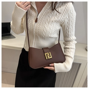 Close-up of a brown matte leather square bag with a distinct golden geometric buckle