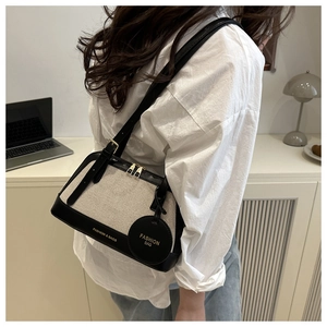 Canvas and leather patchwork tote bag styled on model in a modern office interior