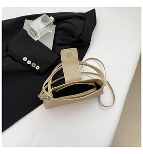 Detailed close-up of champagne gold textured fabric bag with internal zipper pocket