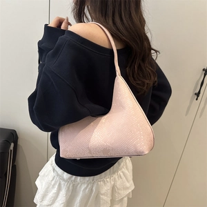 Pink faux snake texture underarm bag shown with minimalist shoulder strap on model