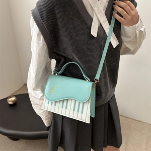 Mint green and white piano-themed shoulder bag with musical note details and strap