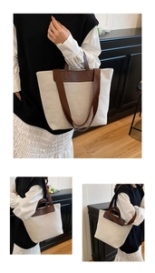 Detail view of large canvas tote bag with brown leather trim and adjustable shoulder strap