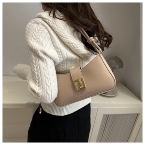 Detail view of beige leather crescent shoulder bag with golden geometric metal buckle