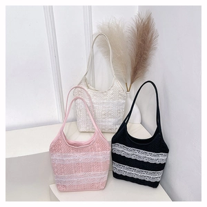 Détail des sacs cabas en dentelle rose, blanc et noir sur un support minimaliste