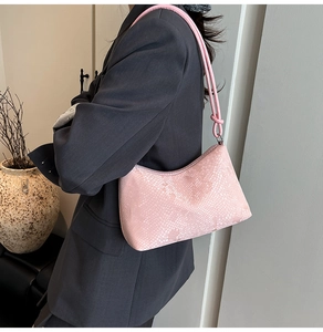 Detailed view of pink snakeskin hobo bag with knotted tubular strap and silver zipper closure
