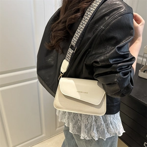 Minimalist bicolor woven crossbody bag with white leather flap and geometric wide strap