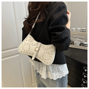 Détail du sac croissant blanc avec motif crocodile, clous dorés et boucle décorative