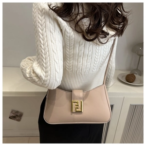 Chic beige leather crescent bag with golden metal logo shown worn on a model's shoulder