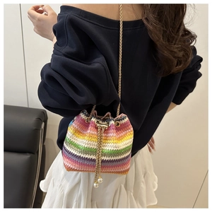Detail of colorful rainbow crochet bucket bag with gold chain and pearl drawstring