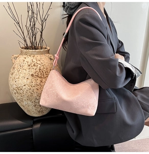 Pink crocodile-embossed hobo bag styled with a gray suit for a chic office look