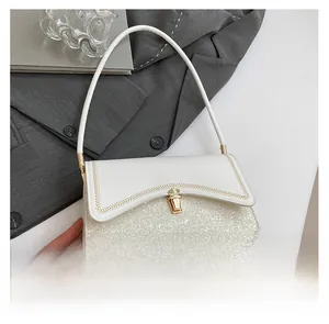 Close-up of contrast crossbody bag featuring sequin patchwork and gold metal twist lock