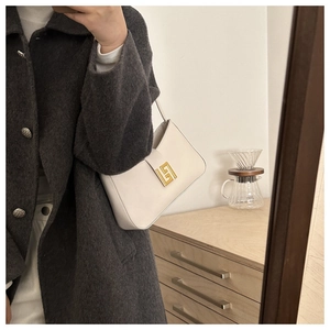 Minimalist white leather bag with golden buckle shown styled with a wool coat