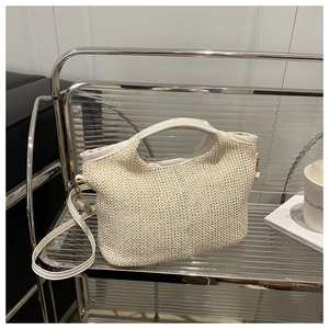 Détail du sac cabas en paille tissée crème avec poignée en similicuir et boucles dorées
