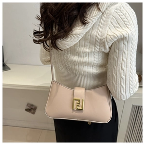 Detail shot of beige crossbody bag with a golden geometric metal buckle on knitwear