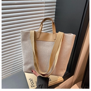 Detail of canvas tote bag showing thick beige texture and brown PU leather handles