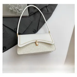 Detail of white baguette bag with wavy flap, gold stitching and shimmering sequins