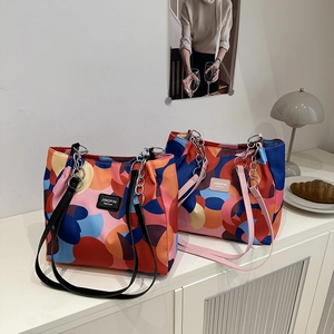 Chic oversized tote bag with bold geometric color block patterns and metal chain straps