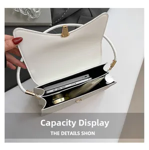 Detail of white mini bag interior showing compartments for phone and lipstick