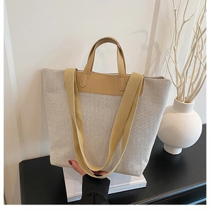 Detailed view of spacious linen tote bag with khaki leather handles and woven shoulder strap