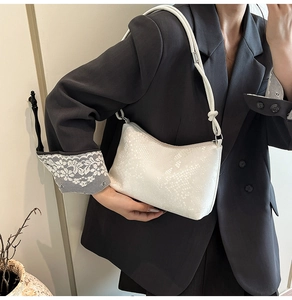 Detail of white faux snake leather texture on women minimalist crescent shoulder bag