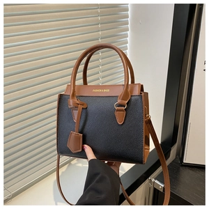 Detail of contrast color crossbody bag with textured leather and gold lettered logo