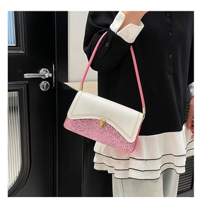 Detail view of pink sequin patchwork and gold metal twist lock on a shoulder bag