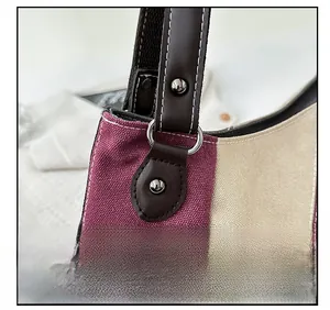 Detail von Metall-D-Ring und Nieten an der weinroten Canvas-Tasche mit feinen Nähten